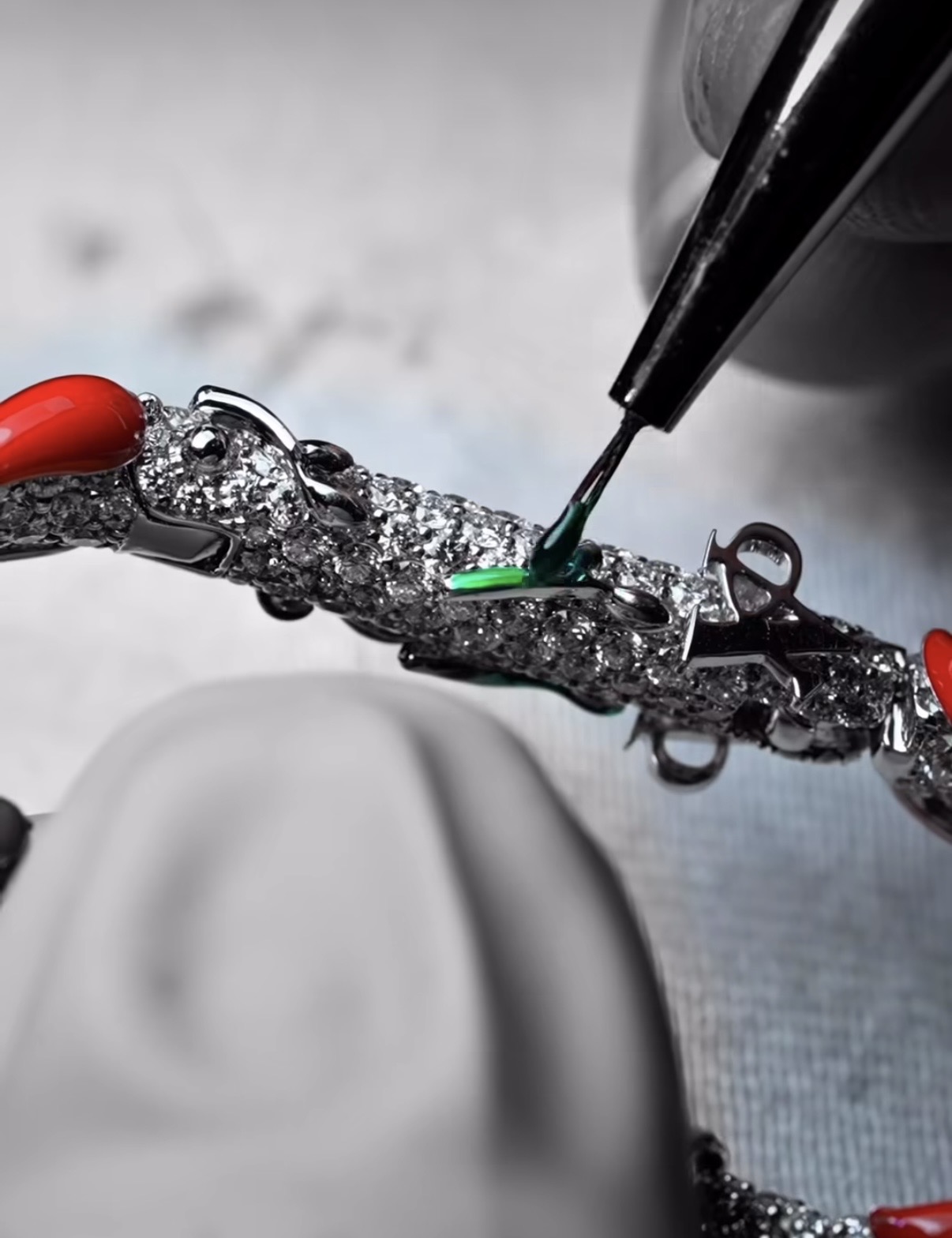 Applying vivid green enamel detailing to the chilli vine on Burna Boy’s custom Nando’s clip — each element set by hand on a bed of pavé diamonds.  Photo credit: A Jewellers