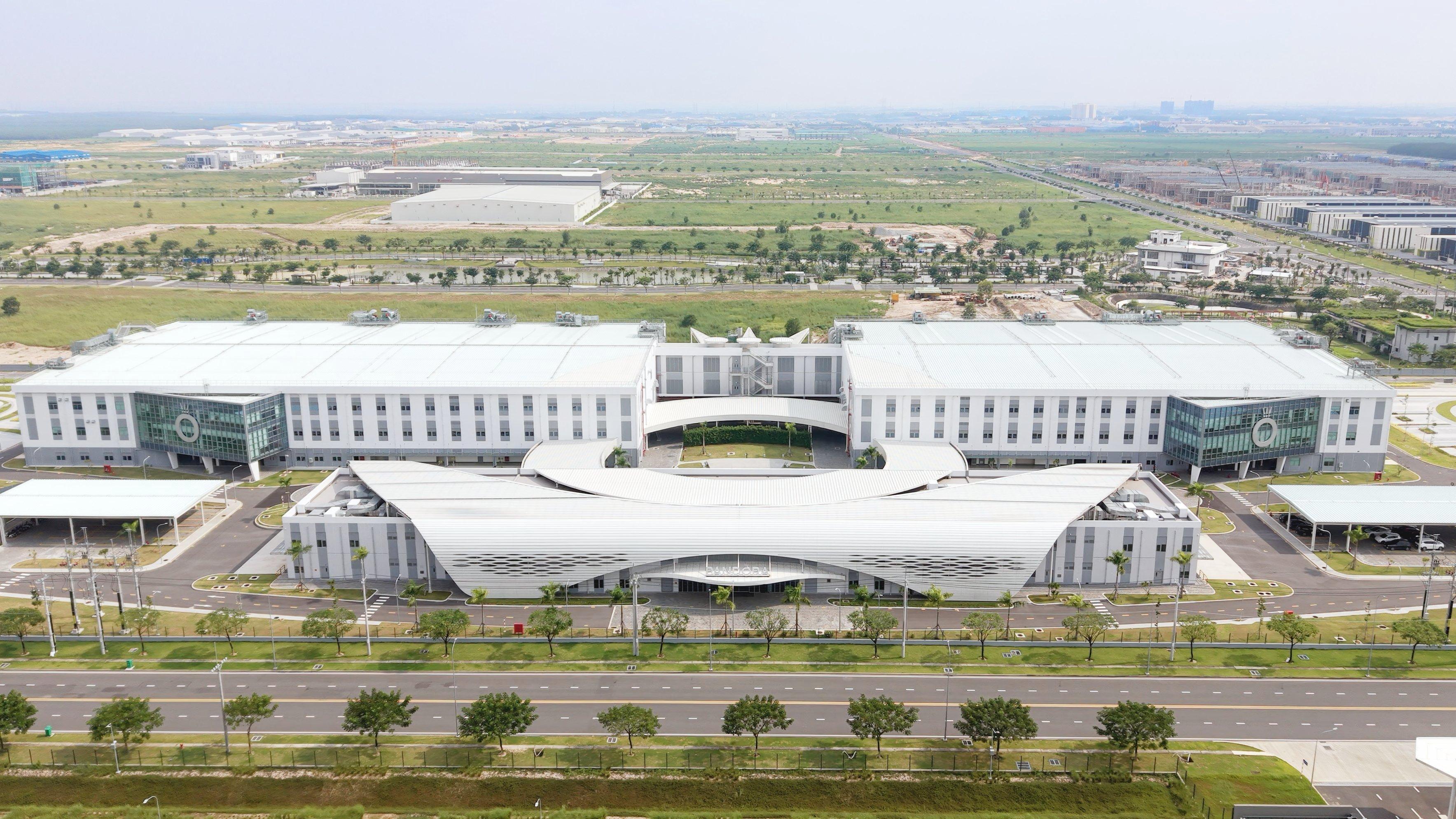 Aerial front view of Pandora’s expansive white jewellery facility, featuring curved architecture, landscaped grounds and two large production buildings.