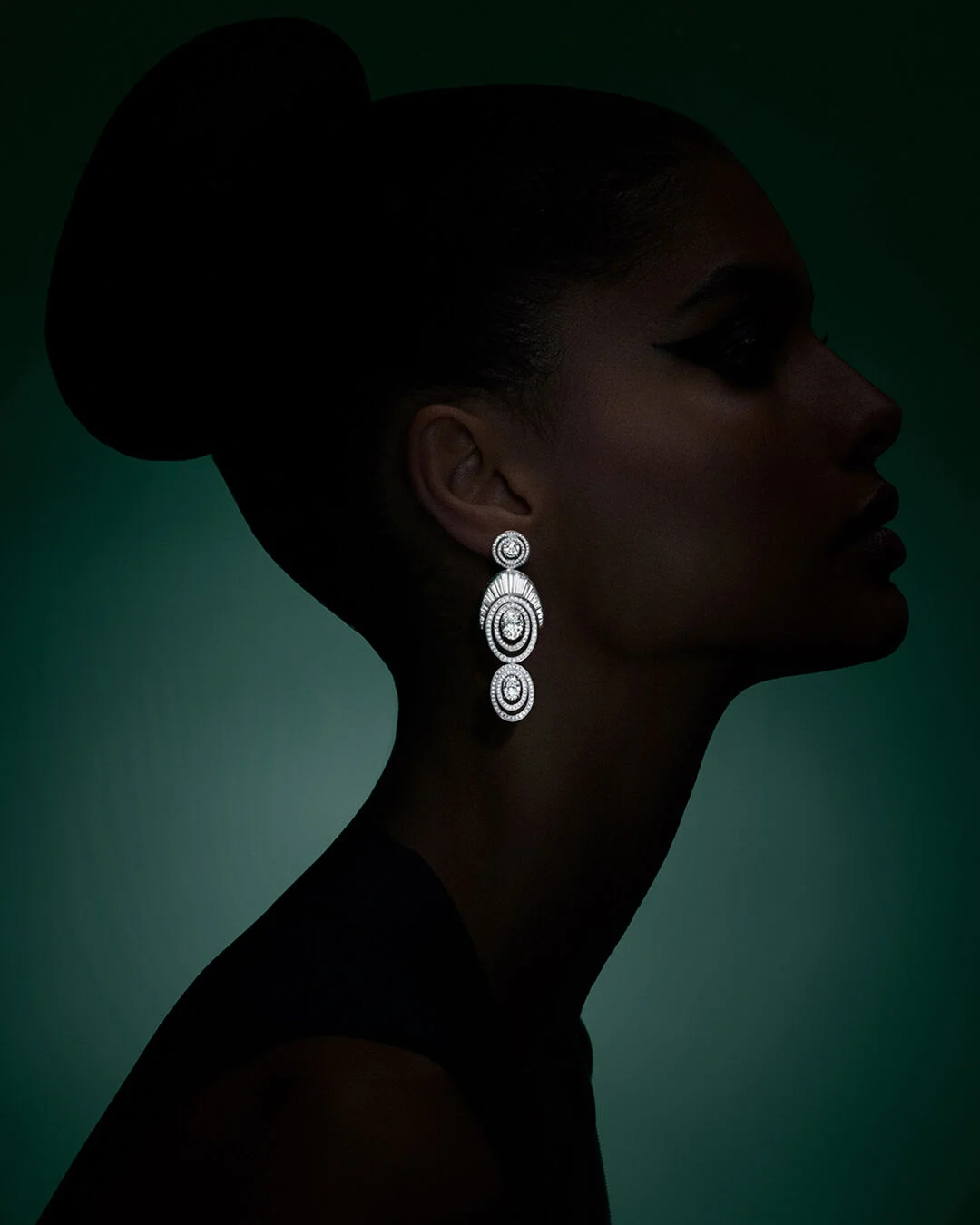 Sculptural concentric ovals form a hypnotic rhythm in the earrings, drawing the eye inward to magnify the brilliance of the central oval diamonds