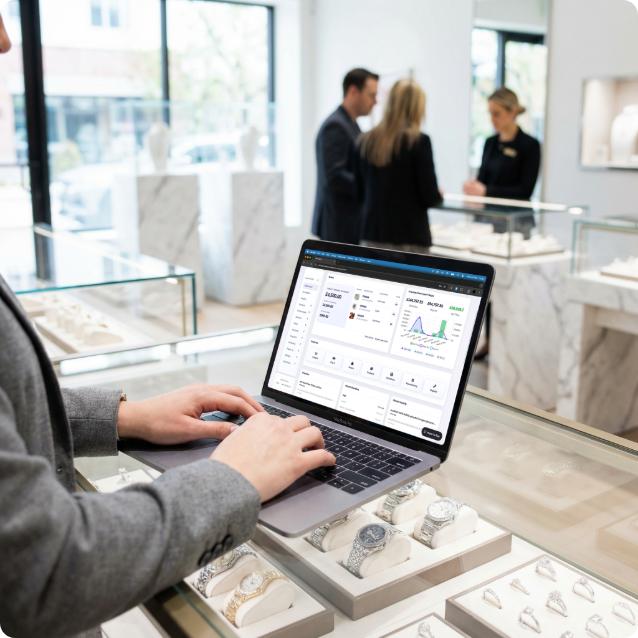 Jewellery retailer using the Stockbox management dashboard on a laptop inside a modern jewellery store.