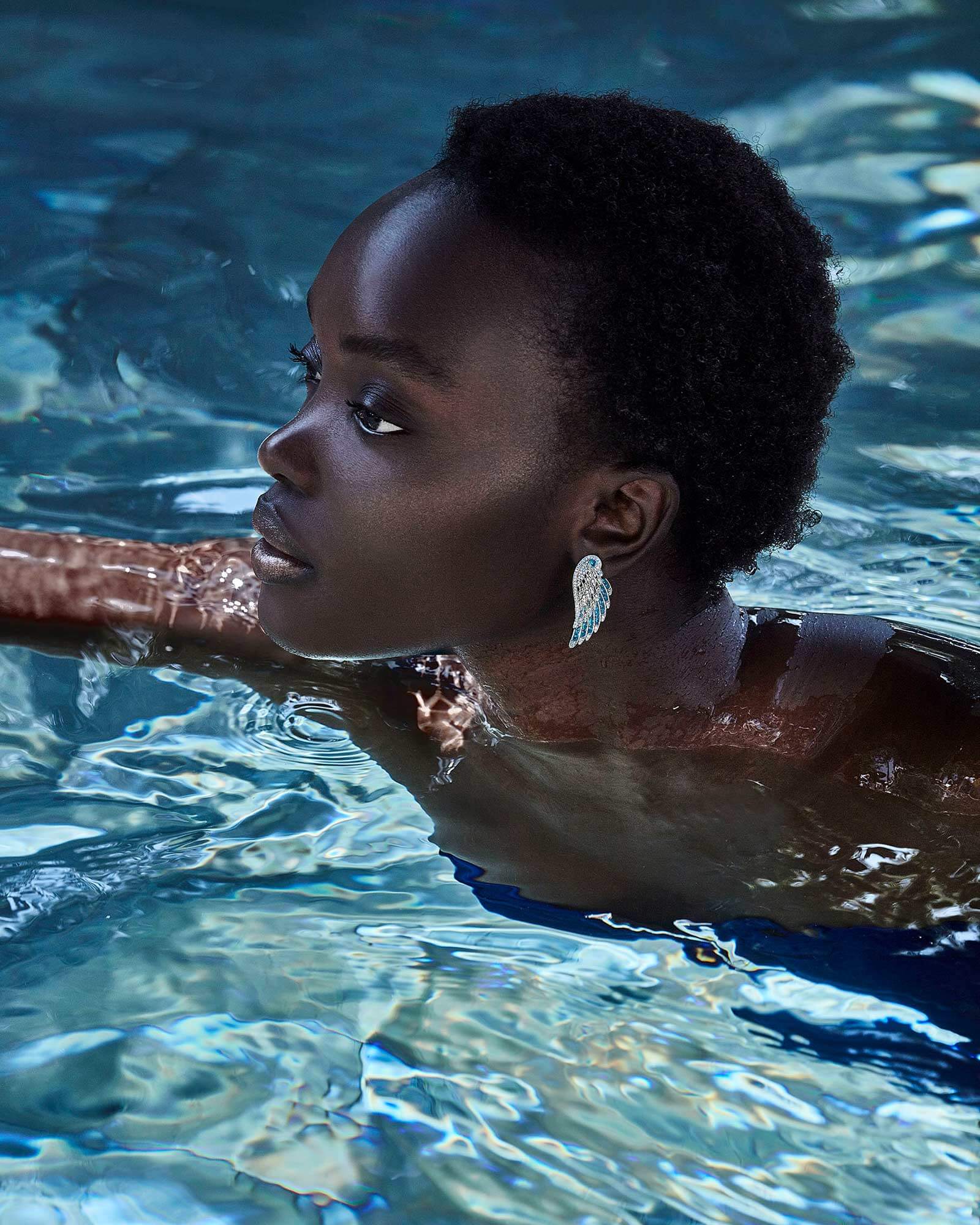 Aquamarine and diamond Wings Embrace earrings by Garrard, captured mid-swim for the Dive In campaign
