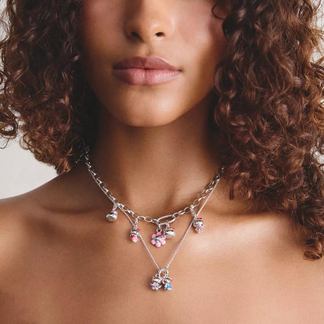 Model wearing layered Thomas Sabo Hello Kitty necklaces featuring sterling silver character charms.