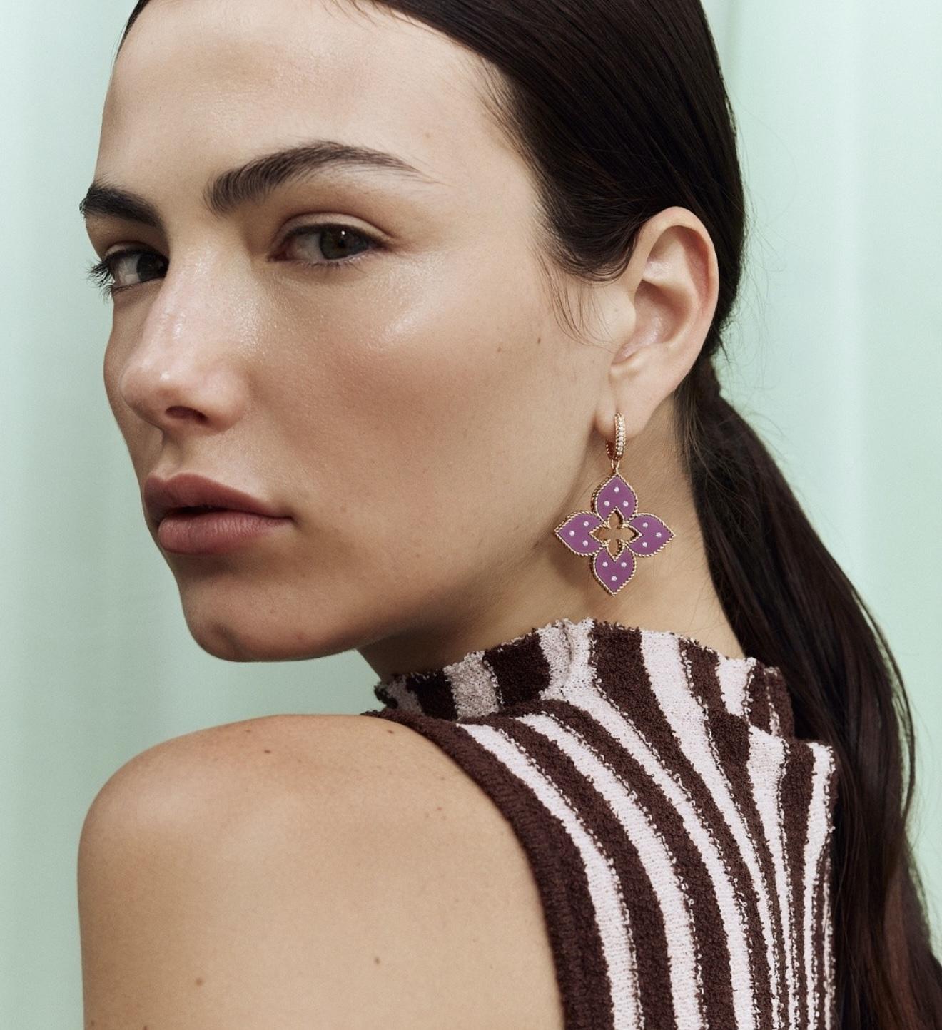 Close-up of a model wearing a violet floral Venetian Princess drop earring by Roberto Coin