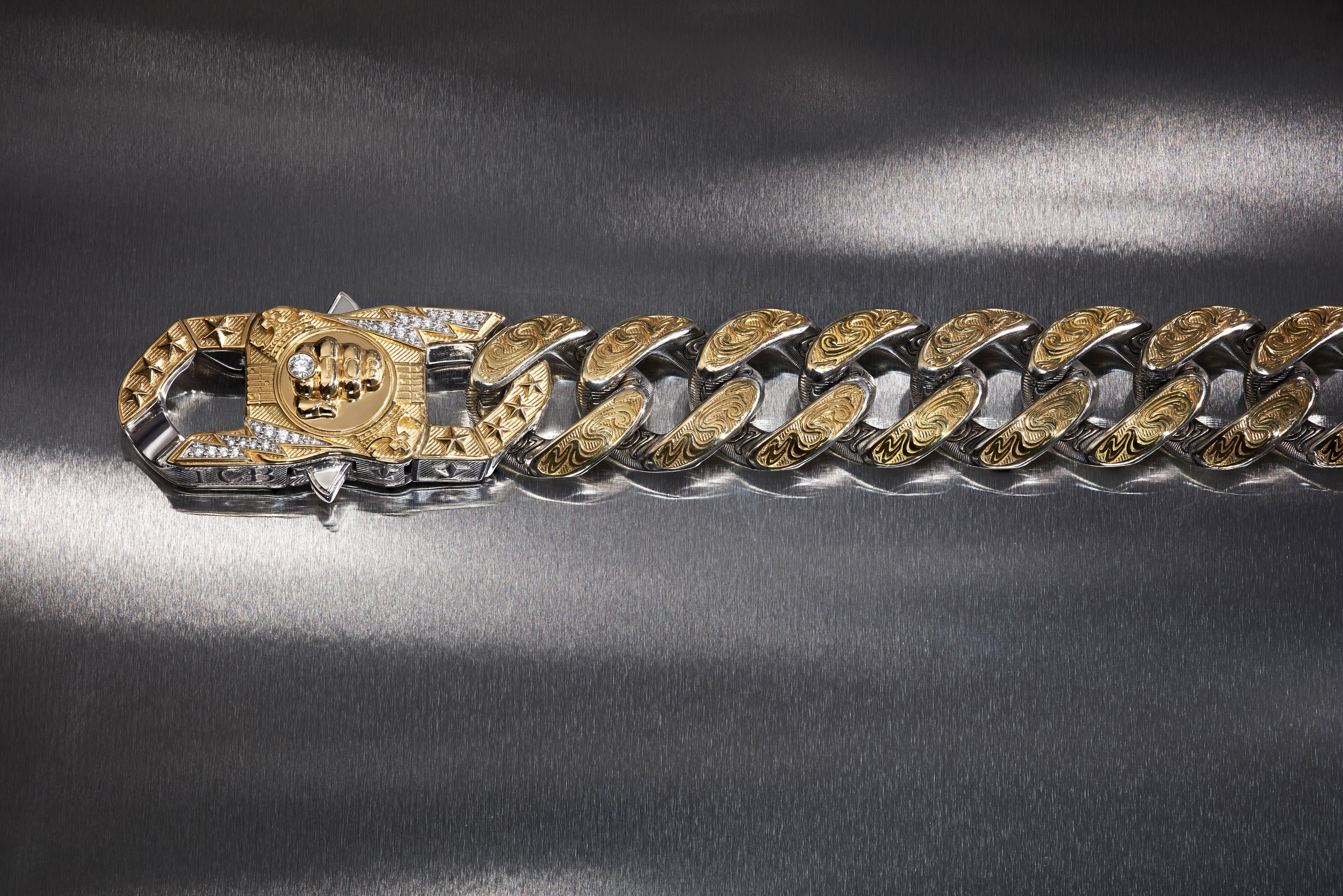 Stephen Webster’s The Bling King Cuban-link bracelet with engraved gold details, white diamonds and a central TCB knuckle-duster fist motif.