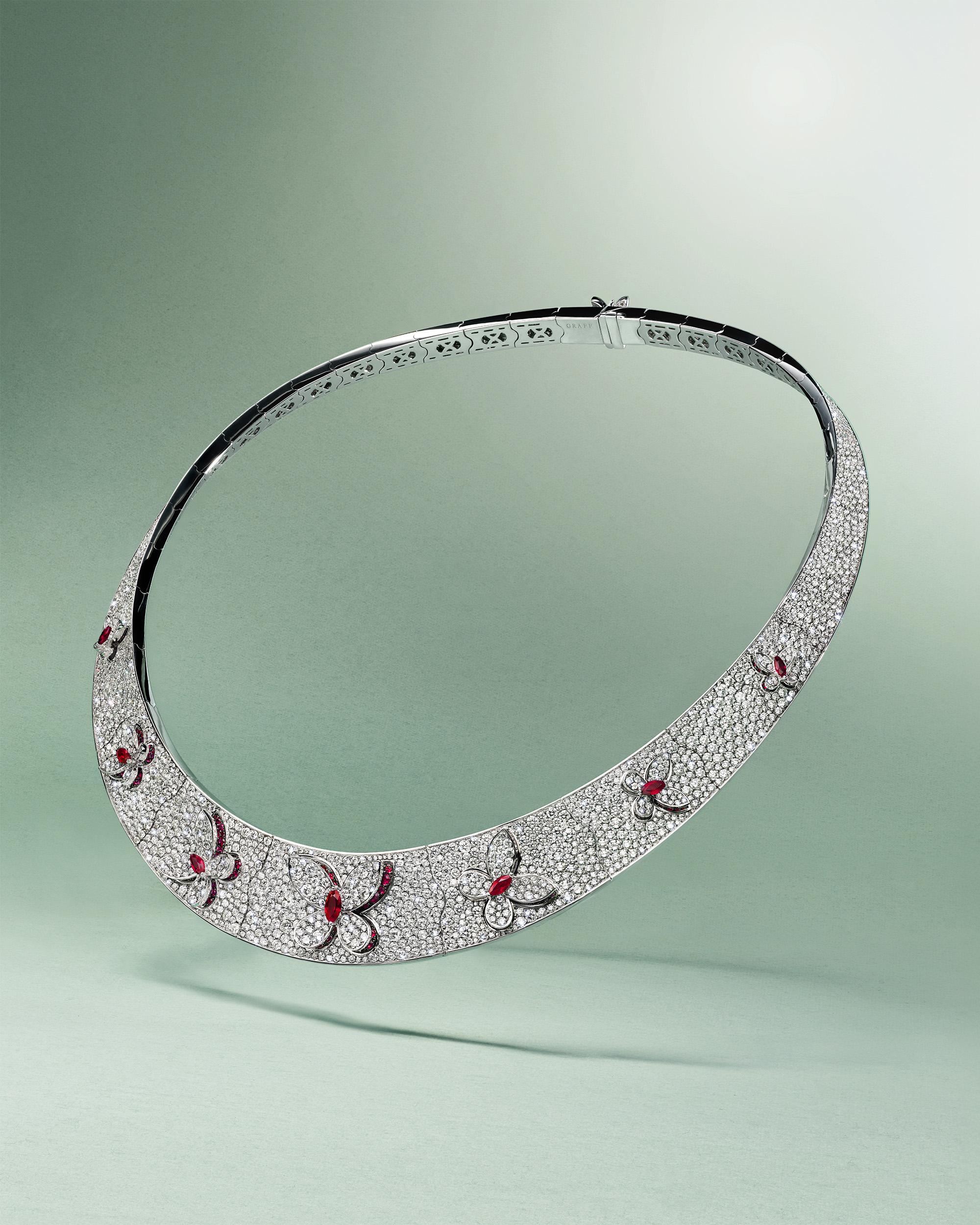 Graff diamond collar necklace with ruby butterfly motifs set in pav&eacute; diamonds on green background