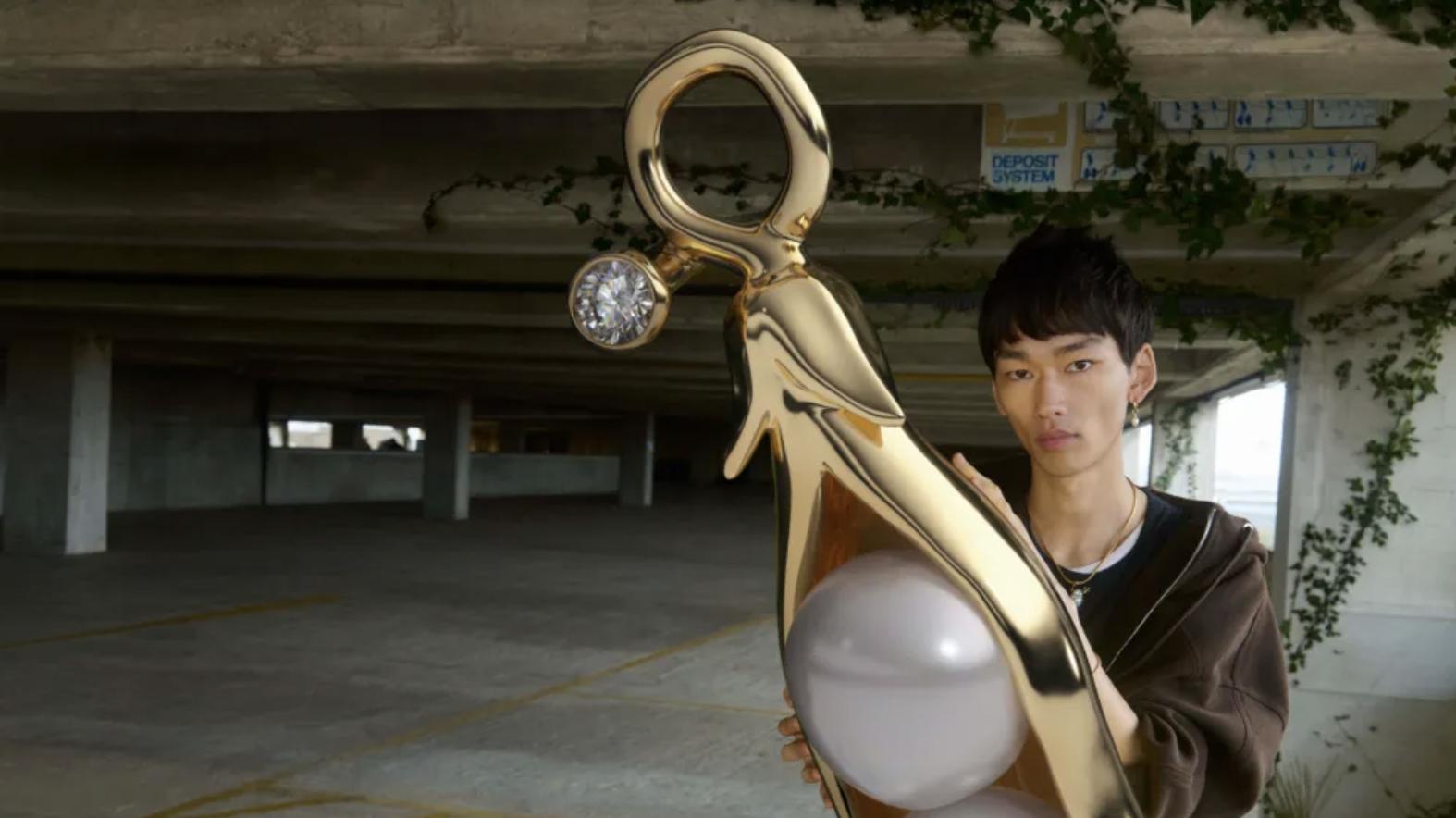 Model standing beside a giant pearl-inspired Pandora Wonders charm installation promoting the limited-edition freshwater pearl collection.