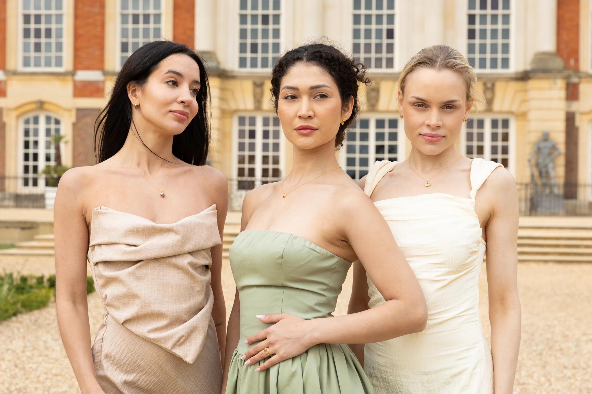 Three models wearing H.AZEEM London jewellery from the Historic Royal Palaces collection outside Hampton Court Palace.