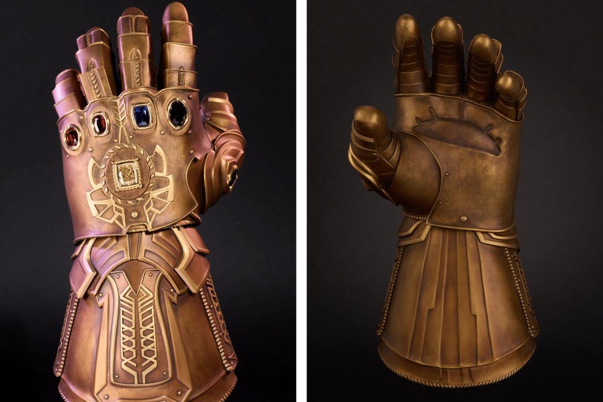 Front and back views of the bronze-coloured Marvel Infinity Gauntlet set with six gemstones against a black background