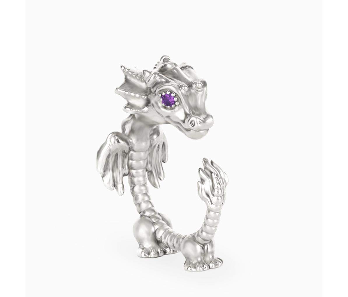 Small sterling-silver dragon sculpture with raised wings, a curled tail and a round purple gemstone eye on a white background.