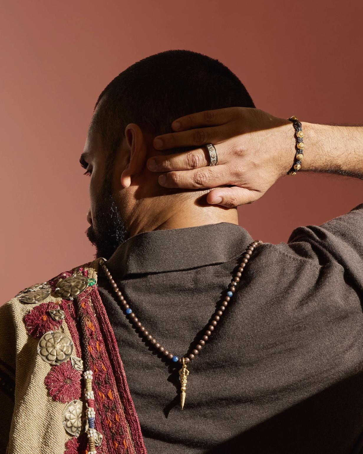Model photographed from behind wearing a Shamballa Jewels beaded pendant necklace, bracelet and patterned ring from the Autumn/Winter 2026 collection