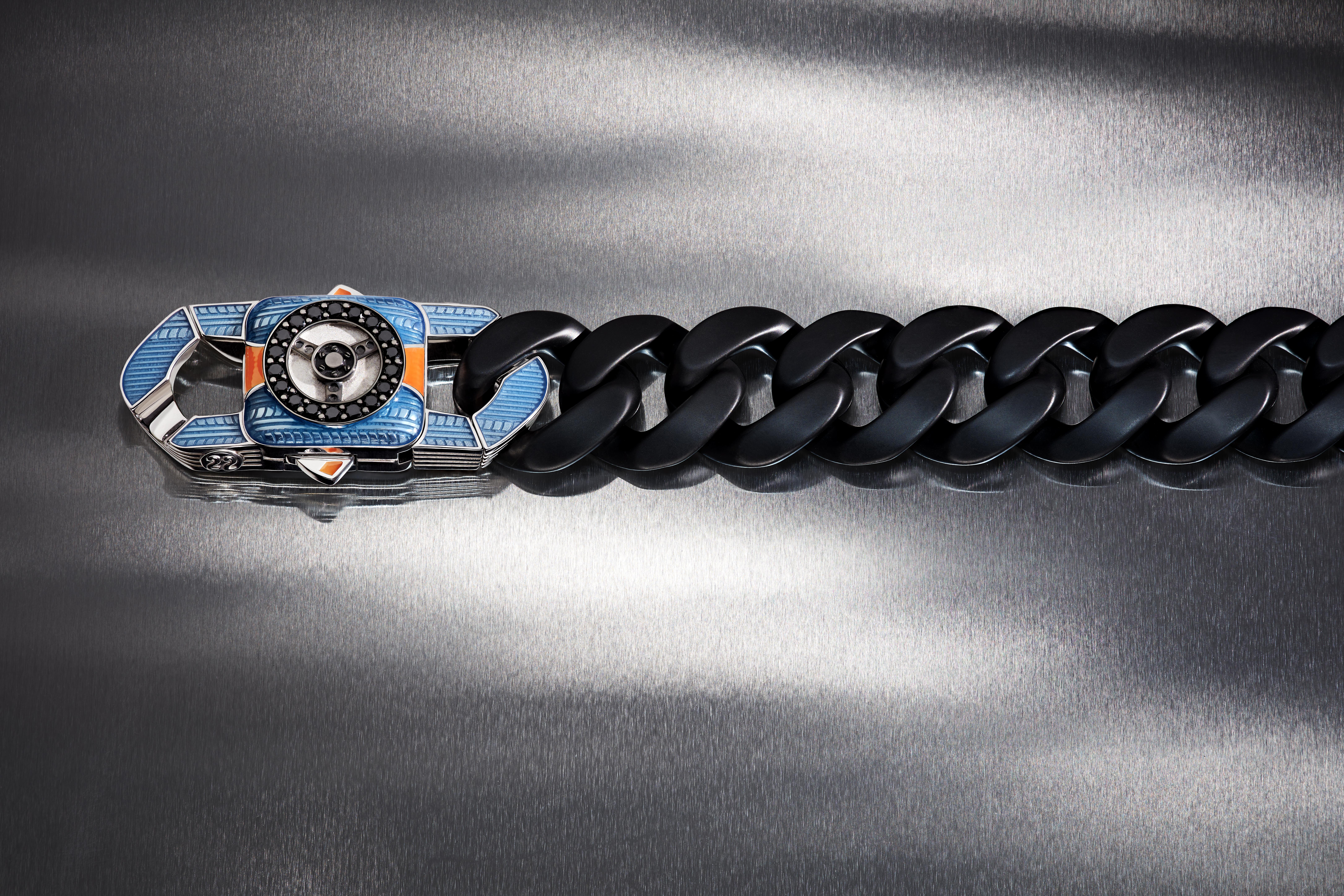 Stephen Webster’s A Great Escape bracelet with matt black ceramic Cuban links, blue and orange enamel, tyre-tread details and a black diamond-set steering-wheel clasp