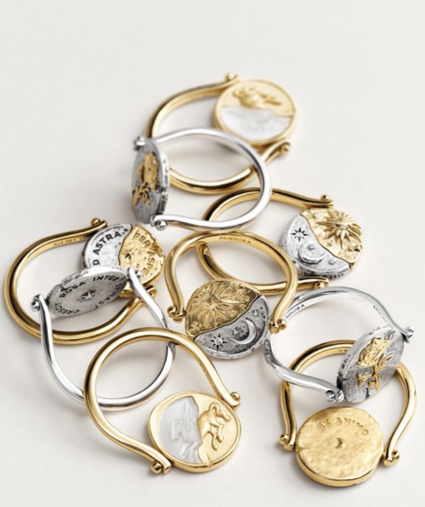 Collection of gold and silver Pandora Talisman rings with rotating medallions featuring celestial, floral and symbolic designs