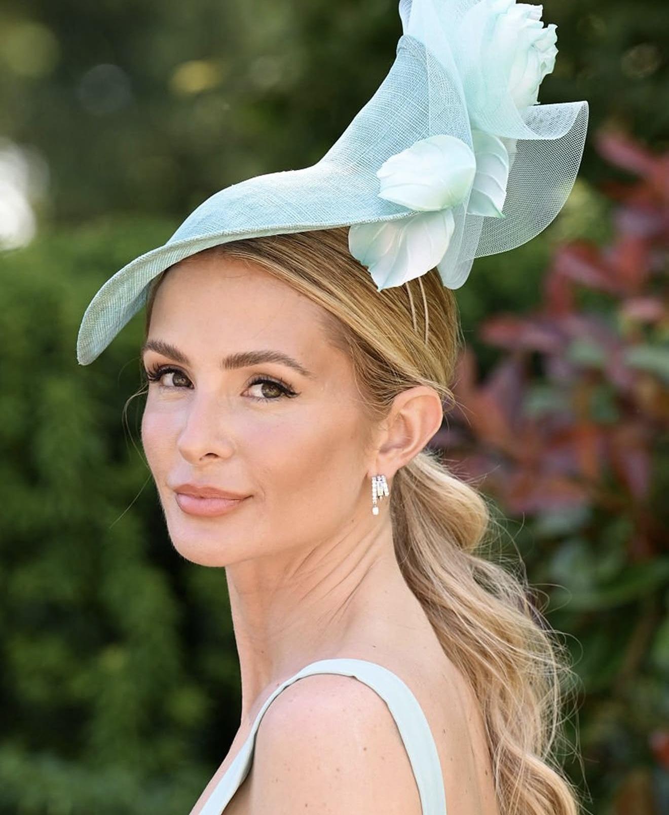 Millie Mackintosh wearing diamond drop earrings and a pale blue fascinator at Royal Ascot.