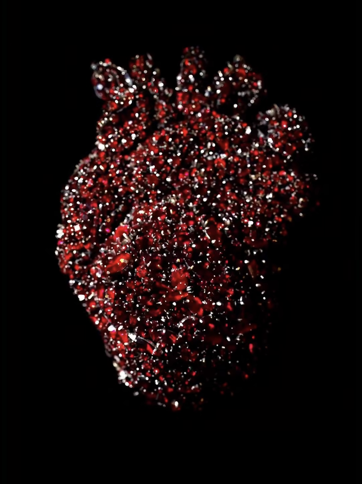 Close-up of the Schiaparelli heart brooch — a sculptural mass of red rhinestones and dark metal, designed to beat like a living organ. Courtesy of Schiaparelli