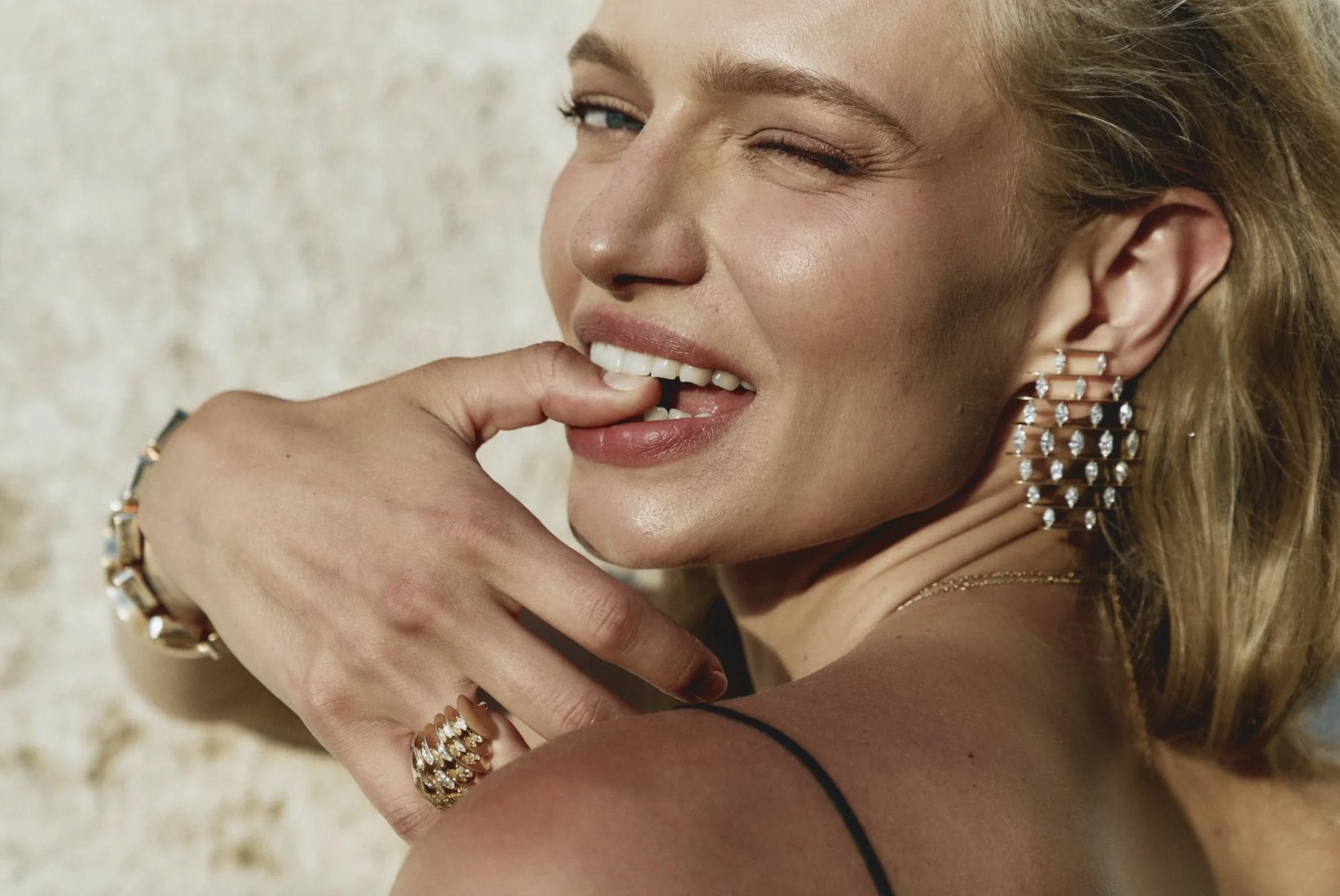 Model wearing a sculptural gold and diamond statement earring, ring and bracelet by NOMIS.