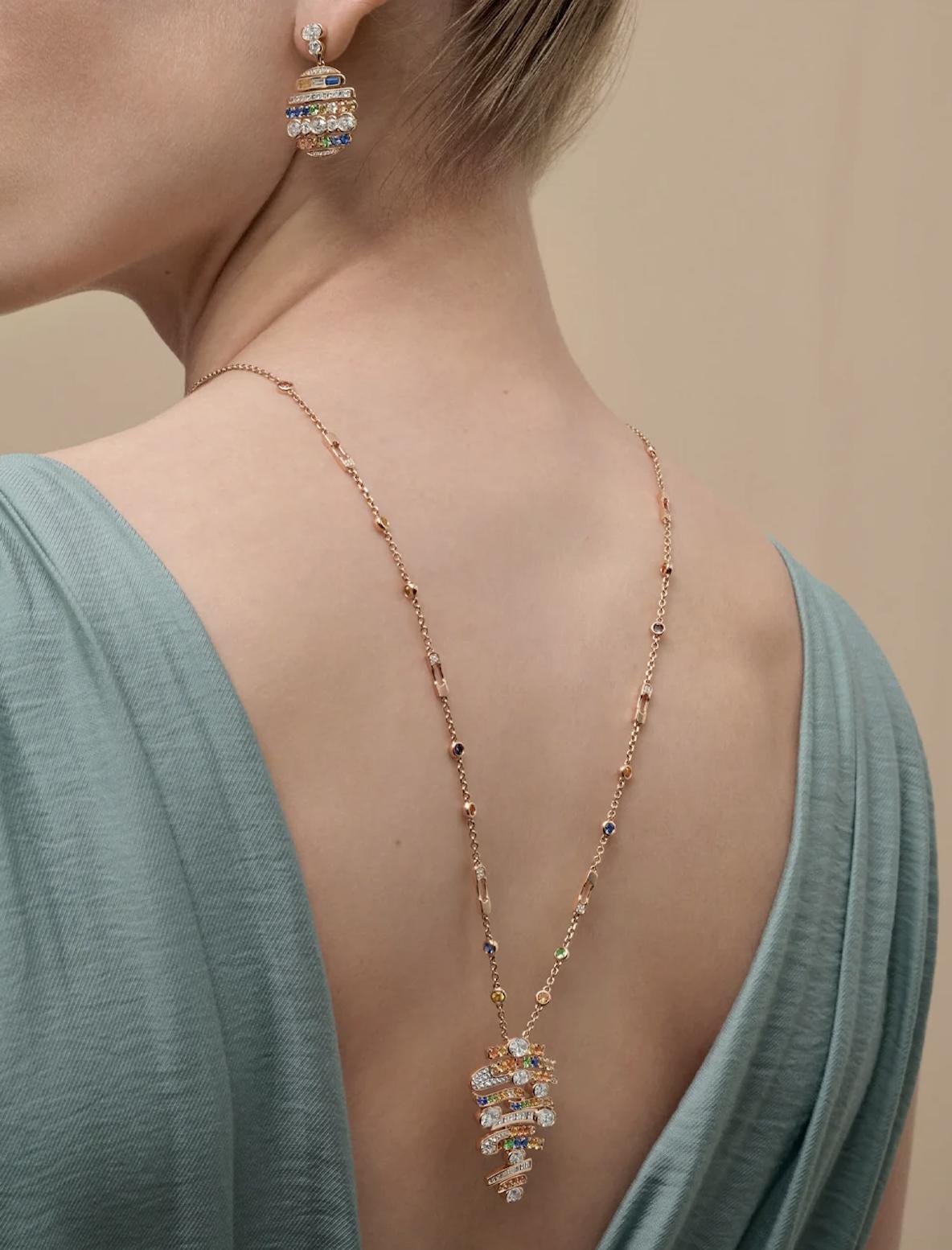 Model wearing a rose gold Boodles necklace and drop earring set with diamonds and multicoloured gemstones.