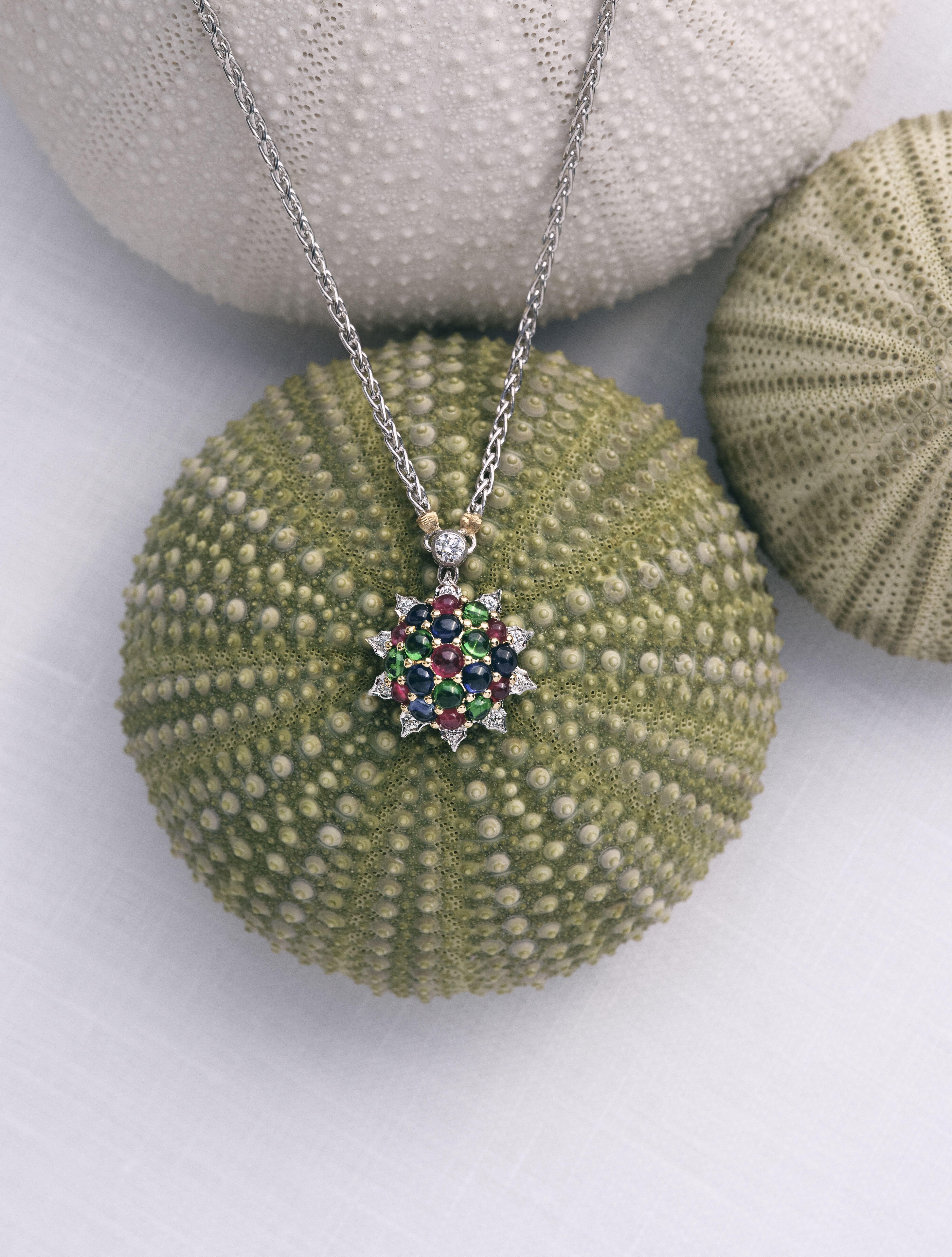 Buccellati Muse collection pendant necklace with multicoloured gemstones displayed against sea urchin-inspired props.
