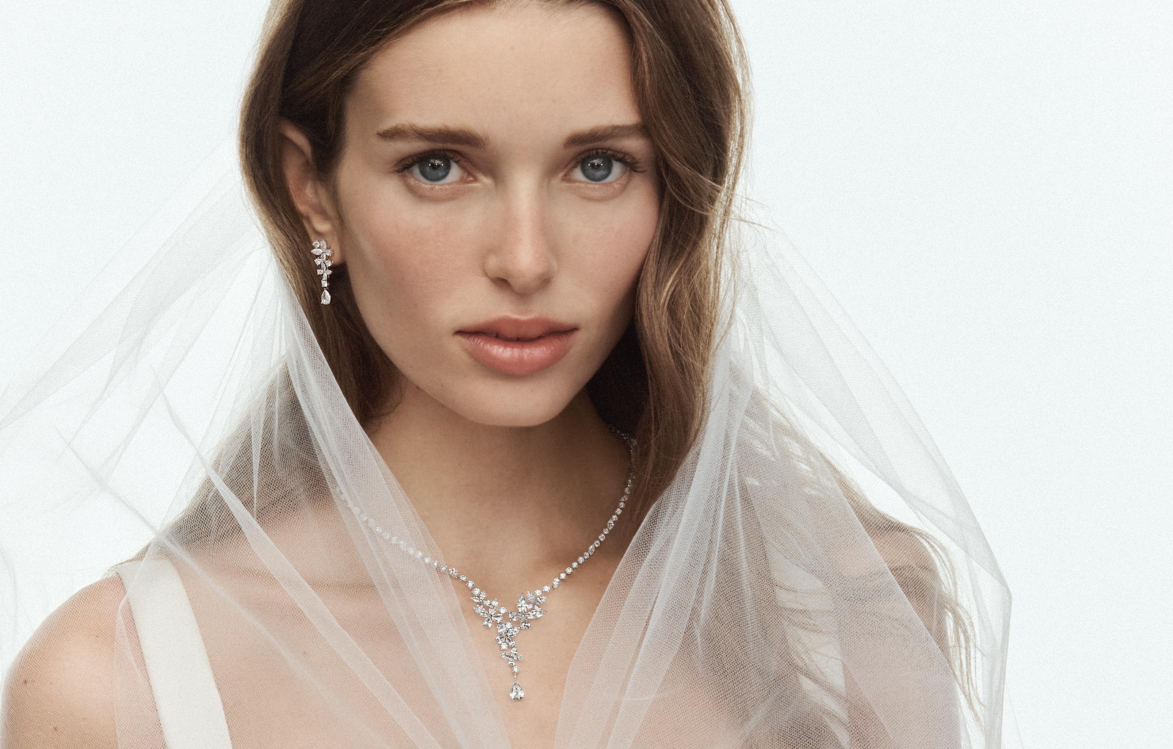 Bride wearing a veil with a Graff diamond necklace, drop earrings, bracelet and engagement ring