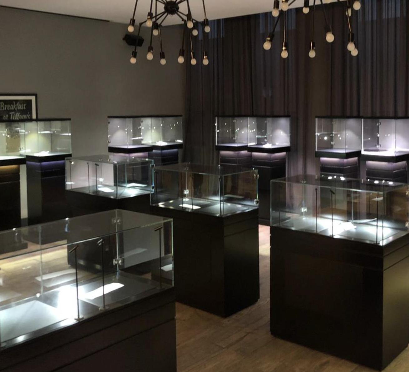 A jewellery exhibition space fully installed with rows of illuminated black pedestal and counter display cabinets supplied by Visionary Displays