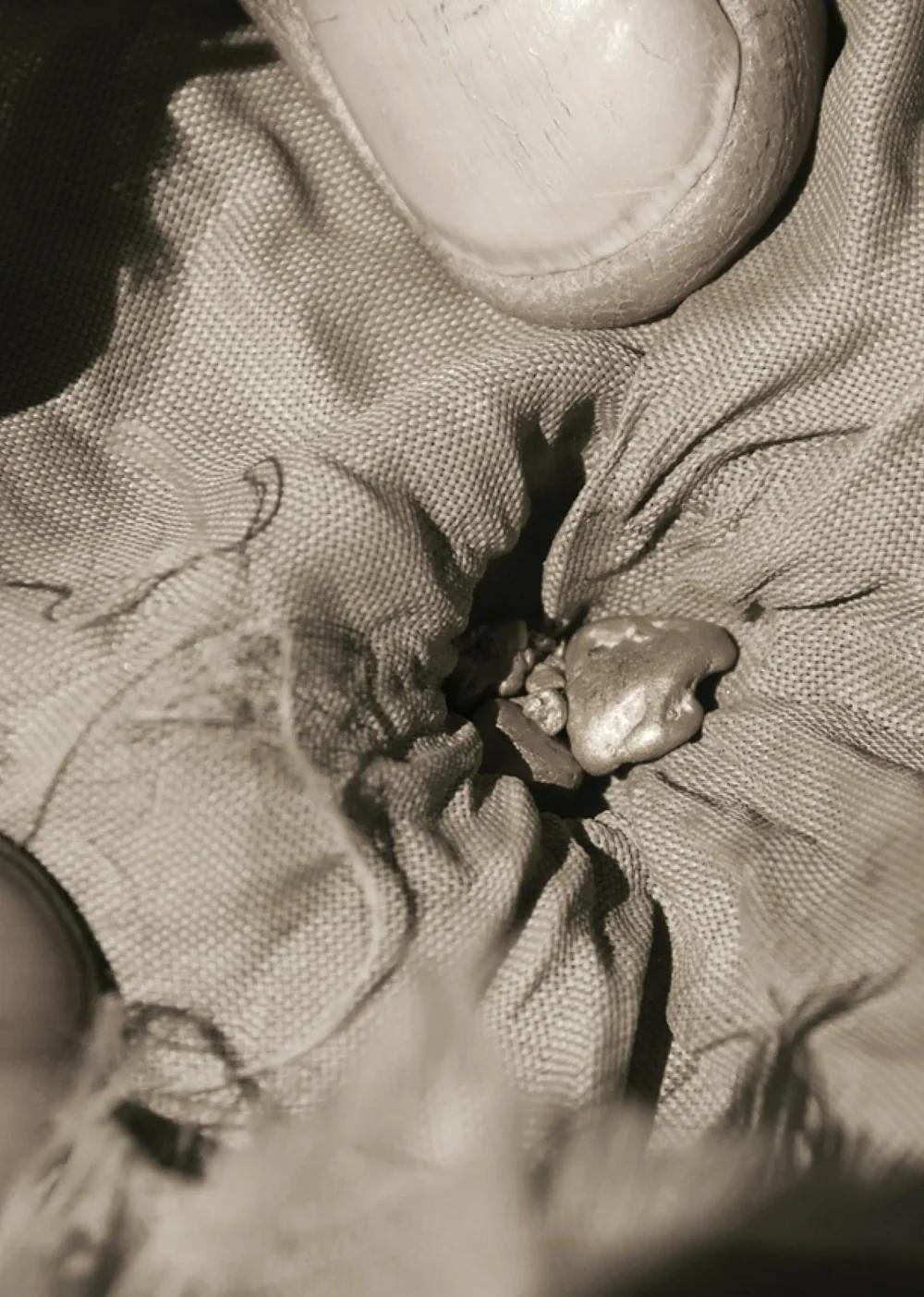 Close-up of raw gold pieces held in fabric, representing responsibly sourced material used in No&euml;n jewellery.