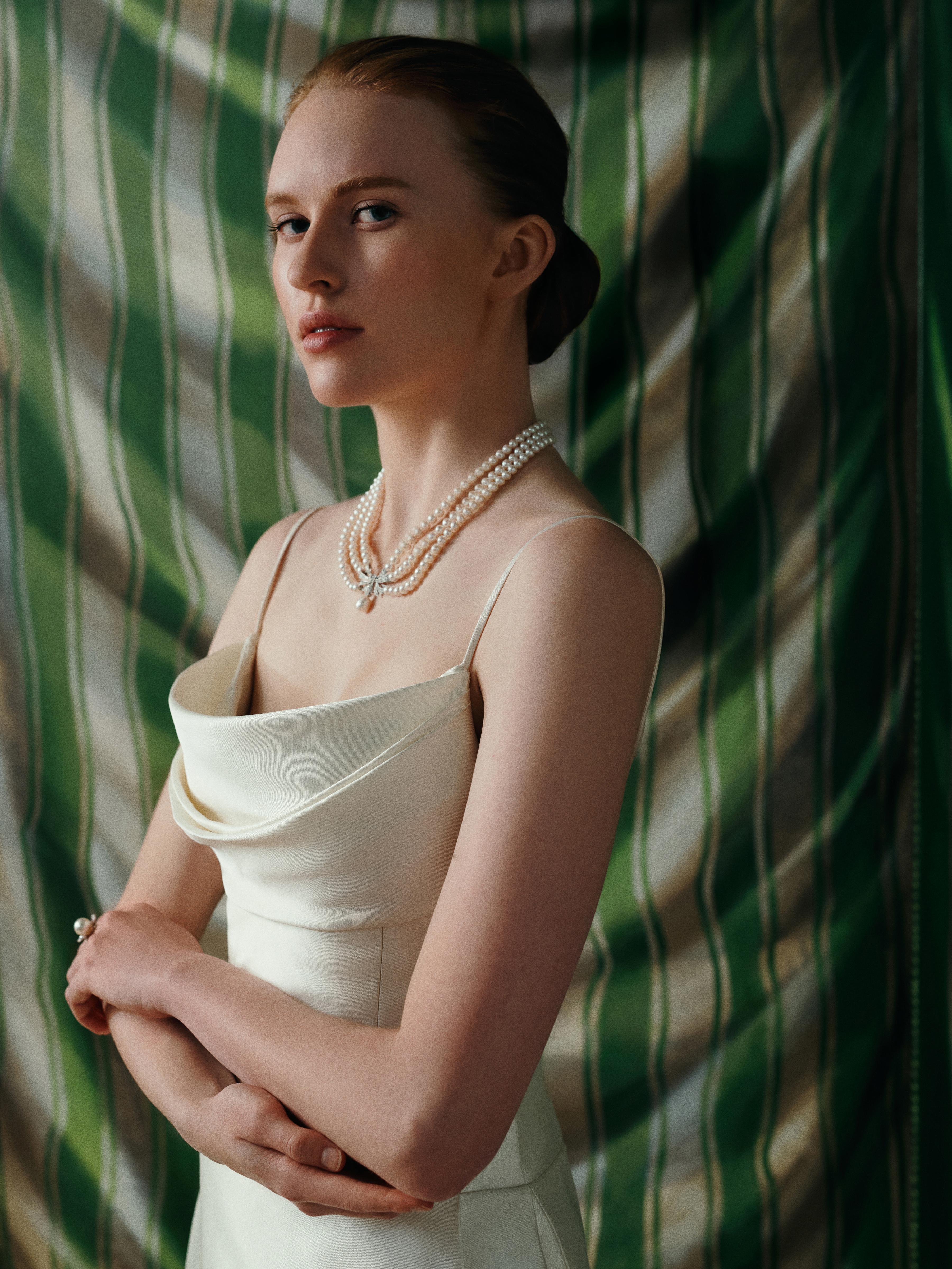 Model wearing a white bridal gown styled with a multi-strand pearl necklace and matching pearl jewellery from the Yoko London x Emilia Wickstead bridal collaboration