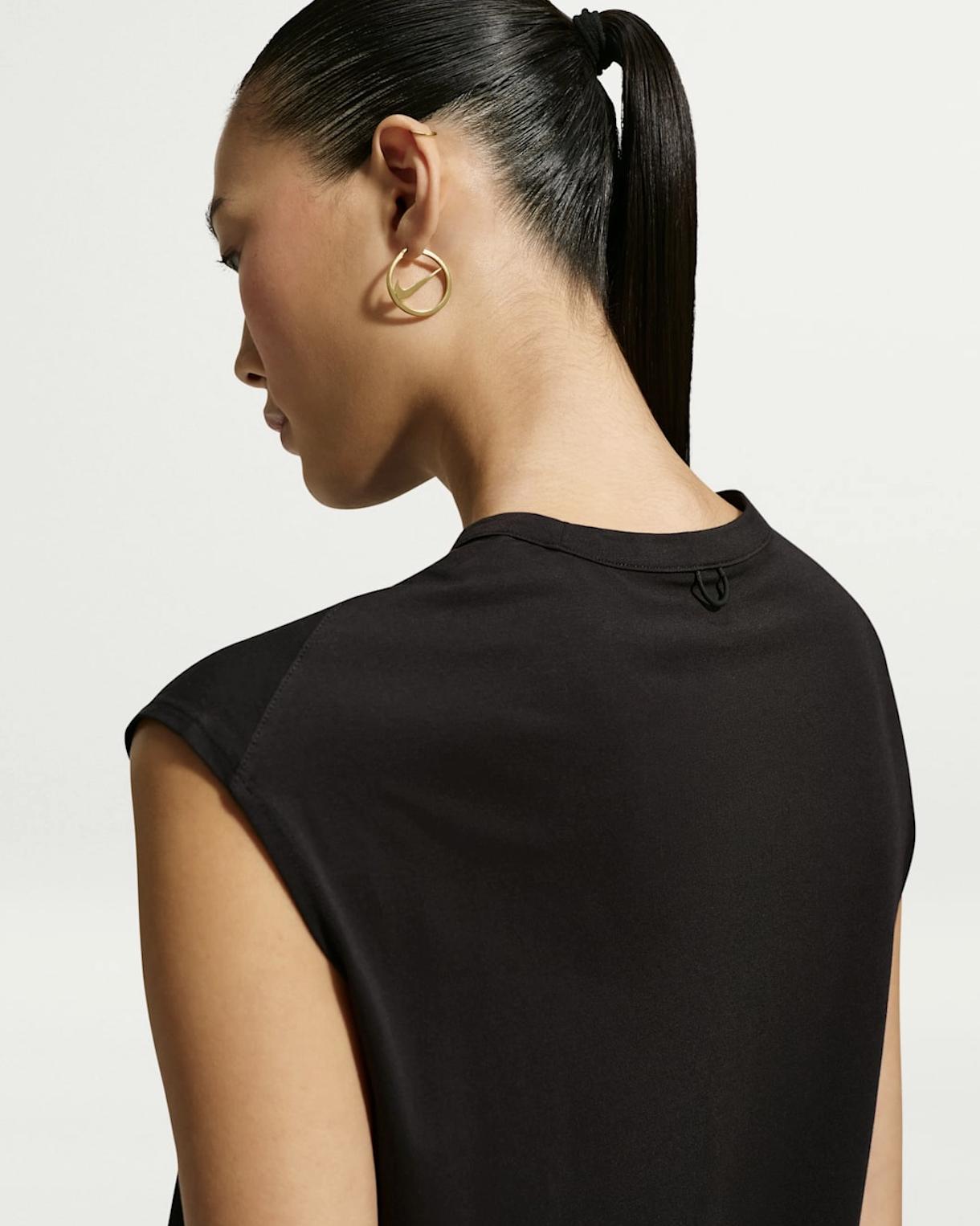 Close-up of a pair of circular Nike hoop earrings with the Swoosh forming a line across each open centre.