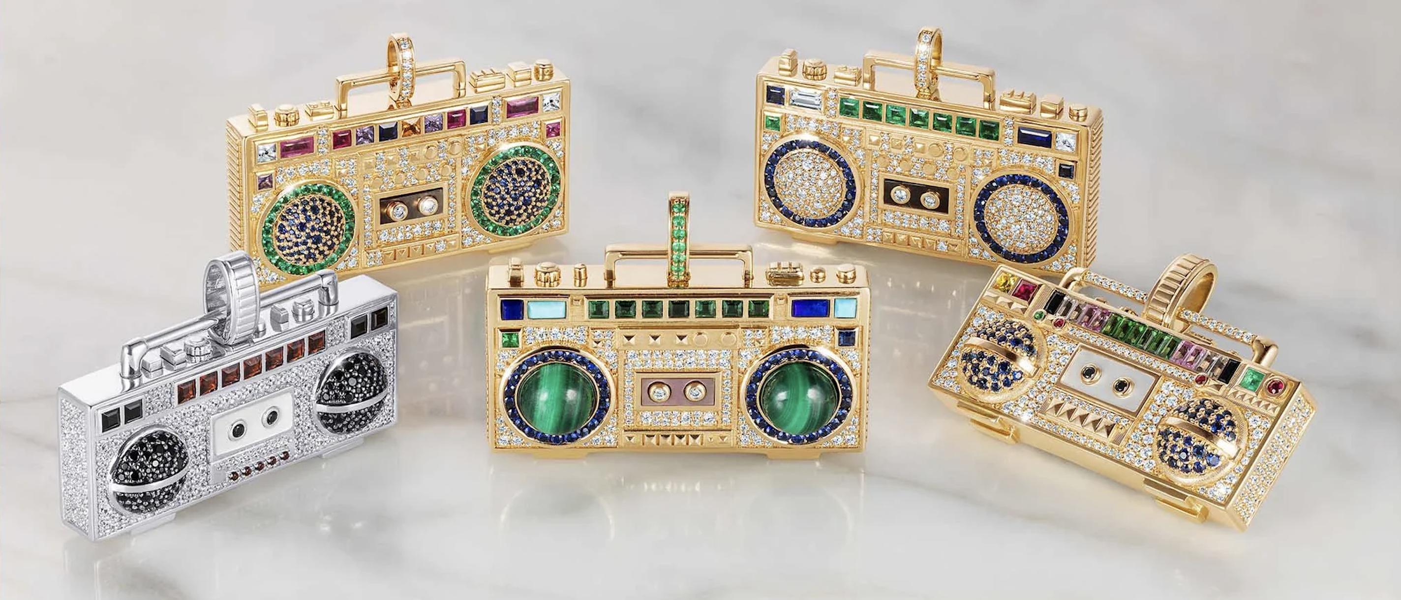 Five NeverNoT Turn It Up boombox pendants in yellow gold and white gold, set with diamonds and colourful gemstones, displayed together from the collection.