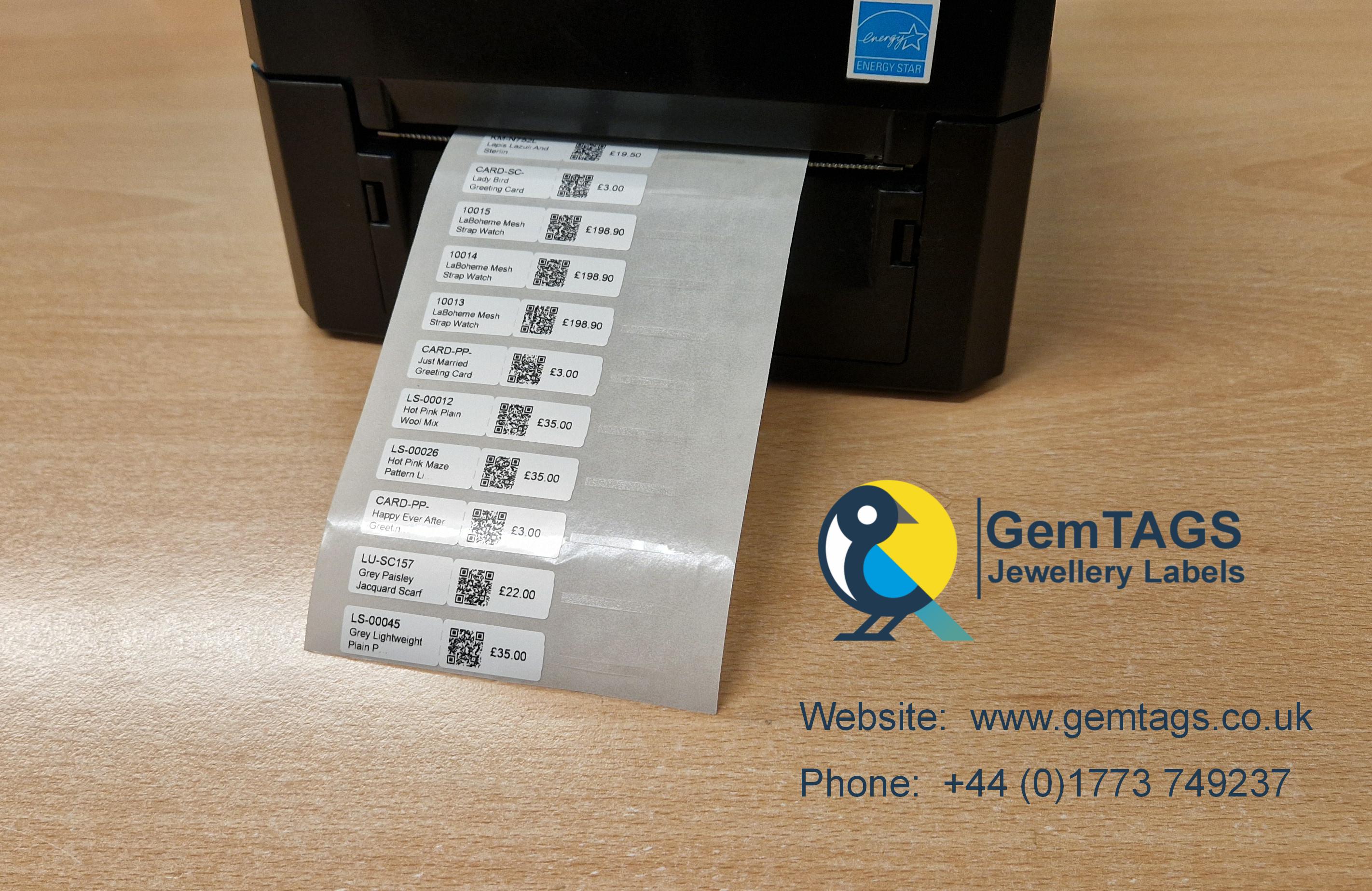 Printer producing GemTAGS jewellery labels featuring pricing, QR codes and product information beside the GemTAGS company logo.