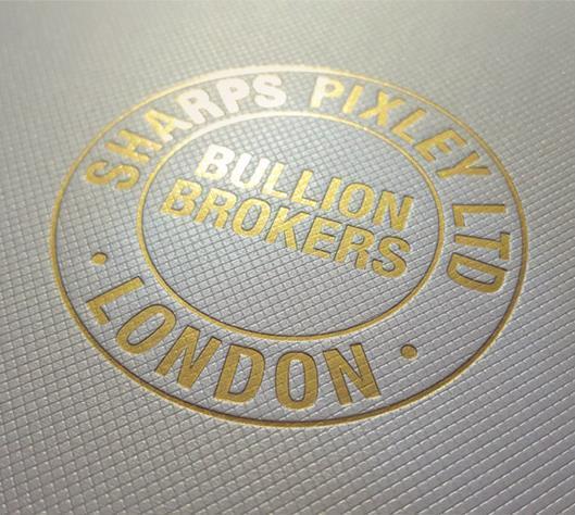 Close-up of an embossed Sharps Pixley Ltd London Bullion Brokers logo in gold lettering
