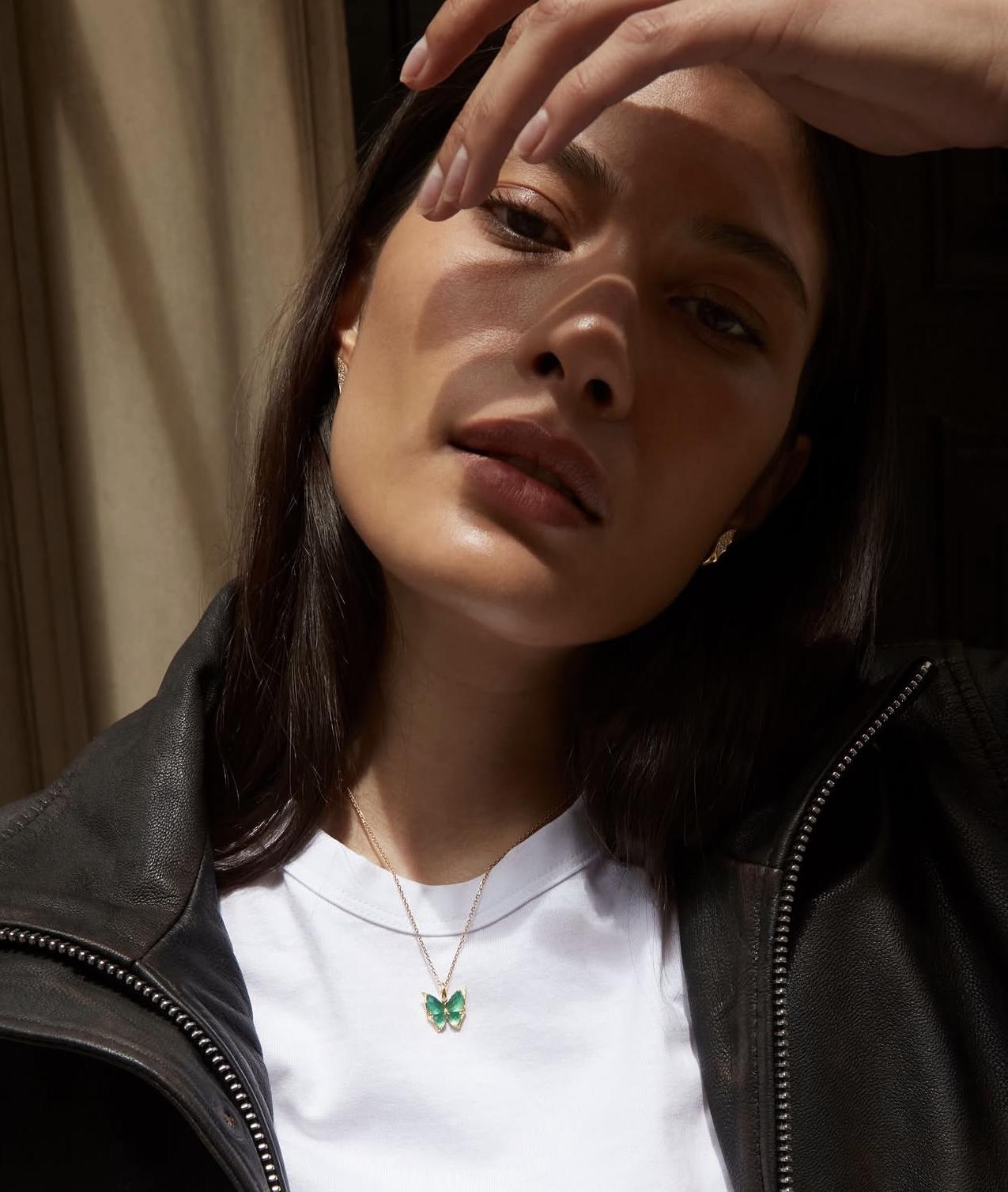 Model wearing Stephen Webster Fly By Night Mini butterfly pendant in Light Green Agate Crystal Haze with white diamonds and 18ct yellow gold.