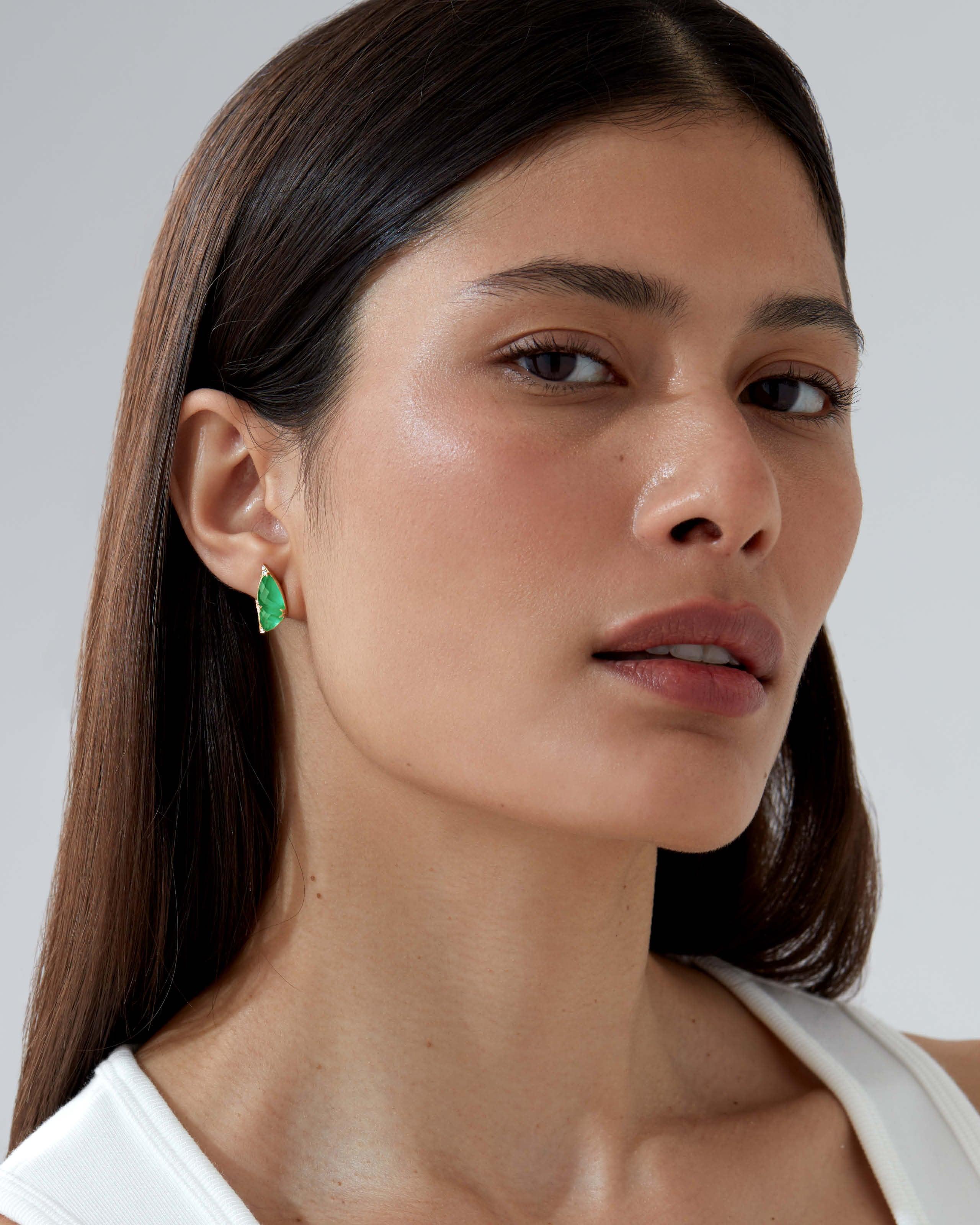 Model wearing Stephen Webster Fly By Night Mini stud earrings in Light Green Agate Crystal Haze with white diamonds and 18ct yellow gold.