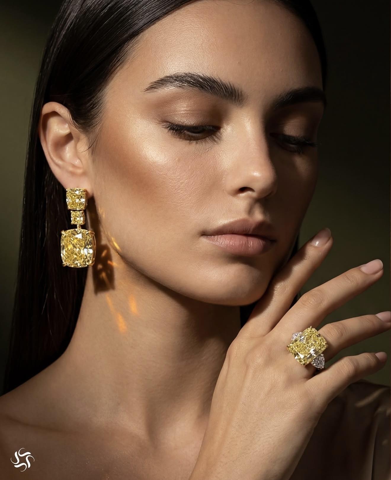 Model wearing Spitaleri Jewellers fancy intense yellow diamond earrings and matching statement ring featuring large cushion-cut yellow diamonds with white diamond accents.