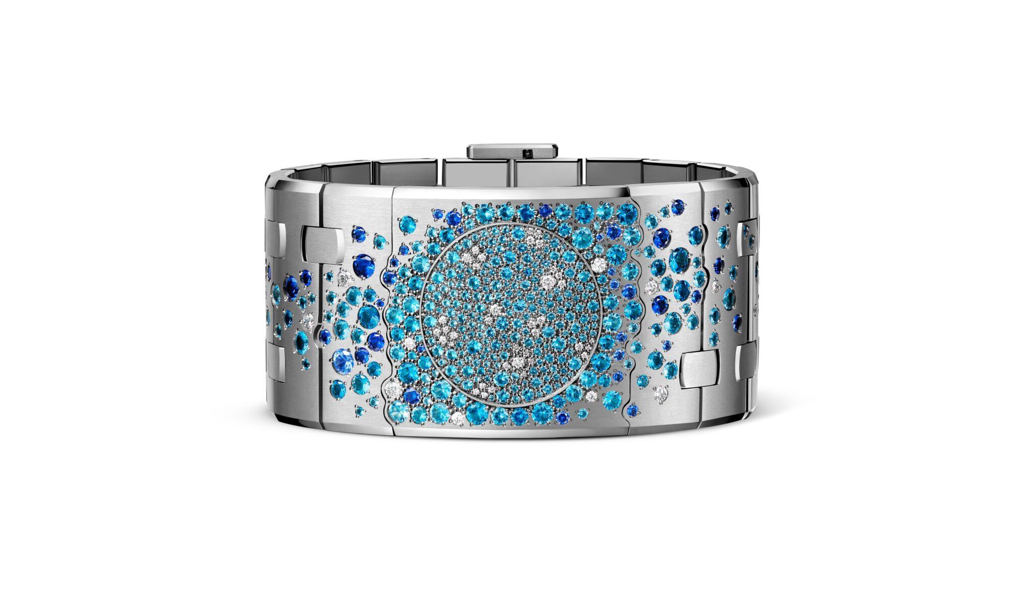 Wide white-gold Audemars Piguet cuff with an articulated Royal Oak design and a circular centre densely set with blue gemstones and white diamonds