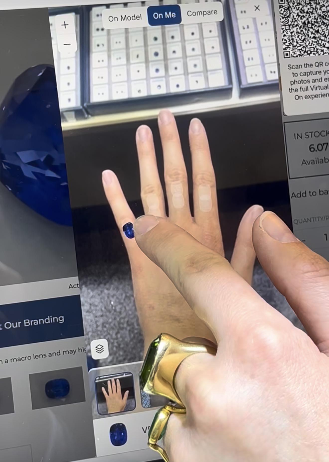A user interacts with CR Gems&rsquo; AI Virtual Try-On feature on a touchscreen device, positioning a blue sapphire against a digital image of their hand to visualise the gemstone&rsquo;s size and appearance. Photo by David Brough, Jewellery Outlook.
