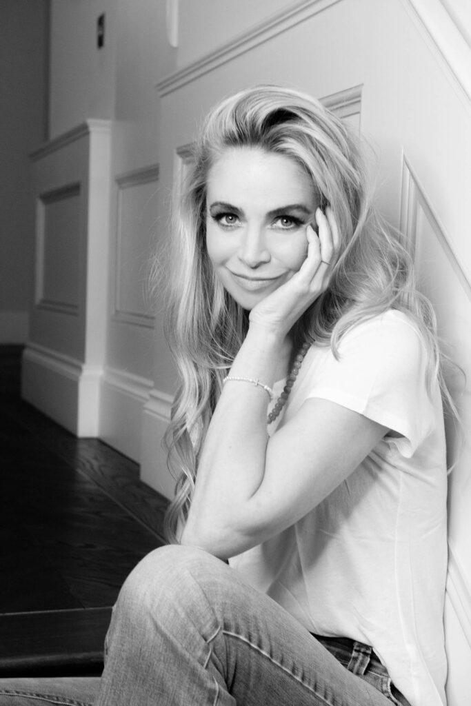 Black-and-white portrait of Tash Jewellery founder Natasha Alizadeh seated on a staircase