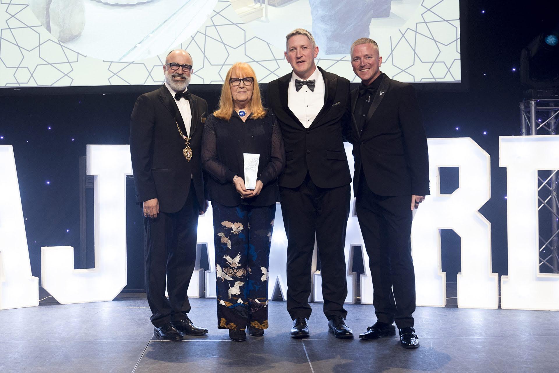 Mehdi Saadian, Sheila Fleet holding the Store Design of the Year award, Martin Fleet and Andrew Martyniuk together on stage at the 2026 NAJ Awards