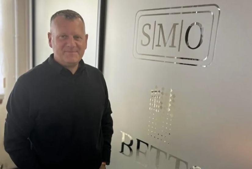 David Fletcher, Head of Business Development – Bridal at The Betts Group, standing beside a branded Betts Metal Sales office partition.