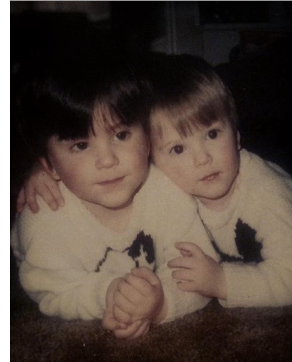 Childhood photograph of twin brothers Paul and Andrew Martyniuk lying close together with an arm around one another