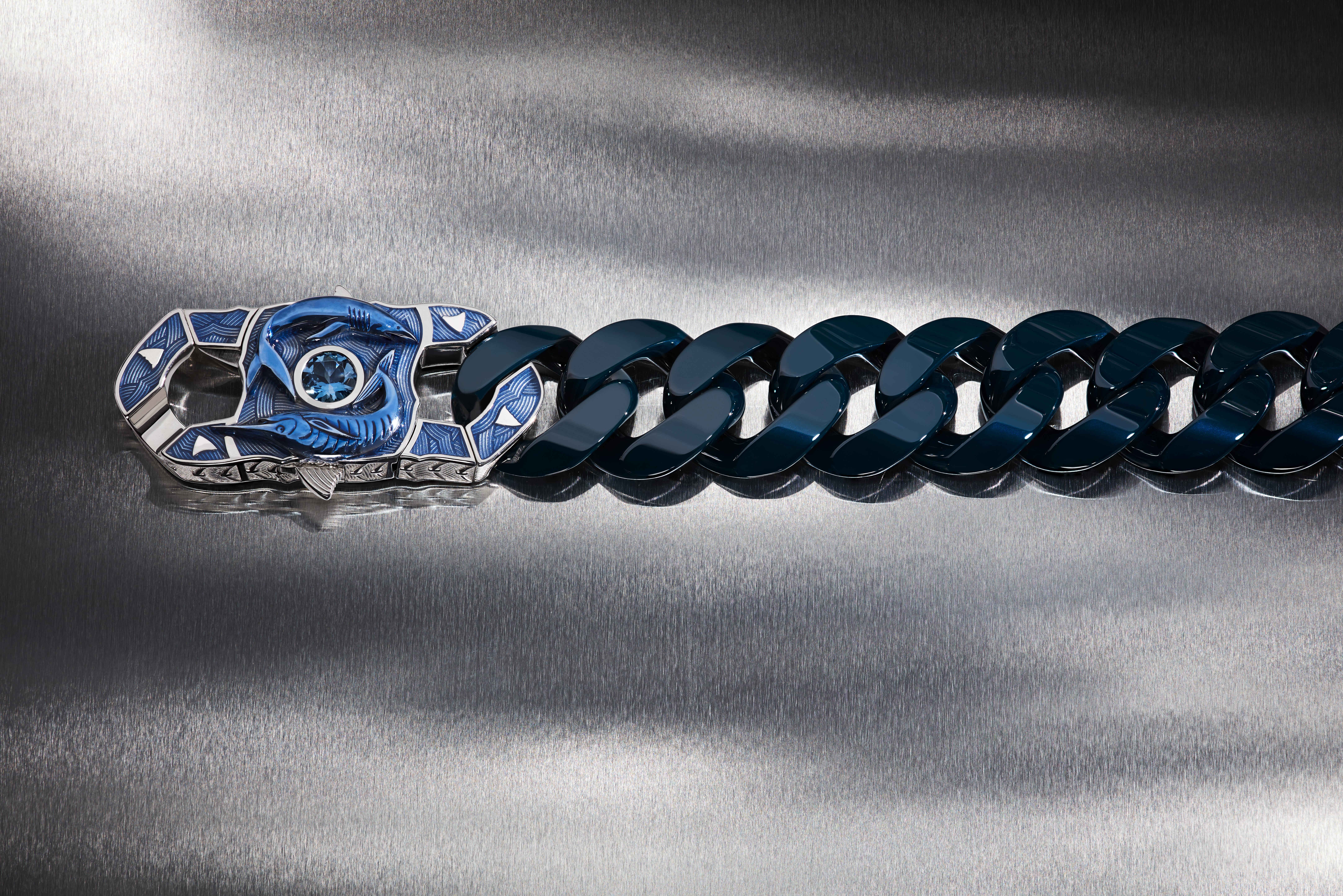 Stephen Webster’s The Fish Brawler bracelet with deep-blue ceramic Cuban links, sculpted shark and marlin motifs, blue enamel waves and a central aquamarine