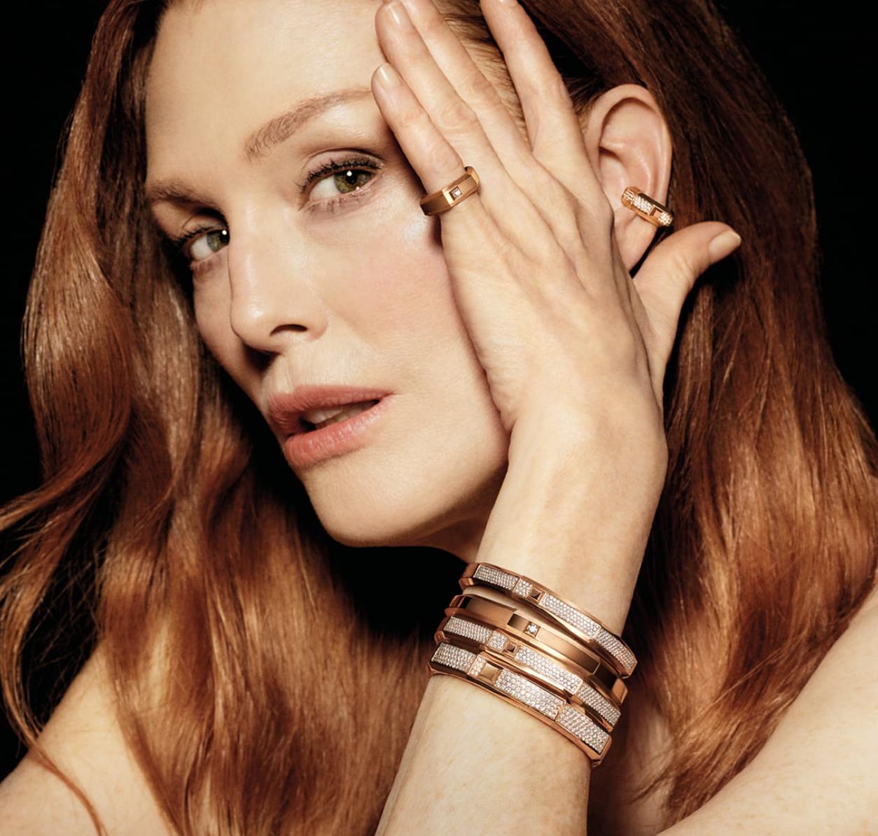 Julianne Moore wearing rose gold and diamond Messika Moderniste bracelets, rings and earrings against a dark background, photographed by Ezra Petronio.