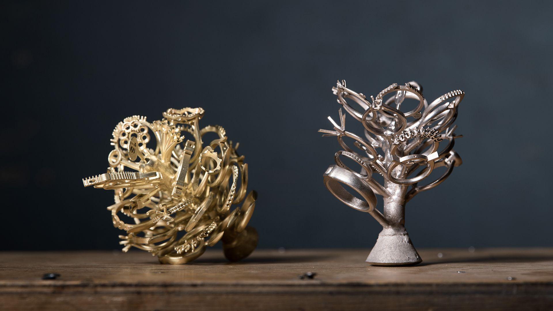 Gold and silver coloured jewellery casting trees displayed on a workbench.