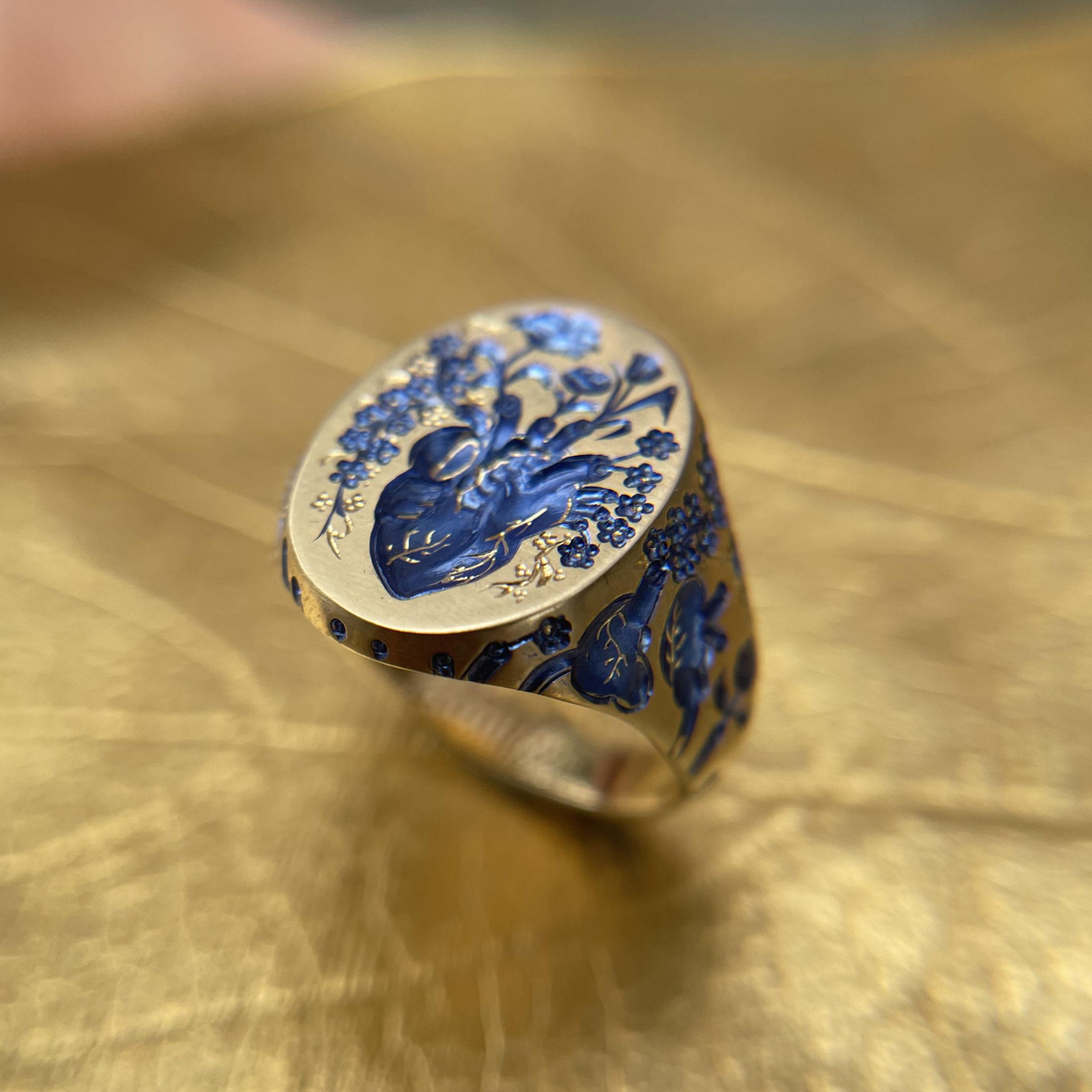 Gold signet ring by Castro Smith, hand engraved in blue with an anatomical heart surrounded by flowers and foliage