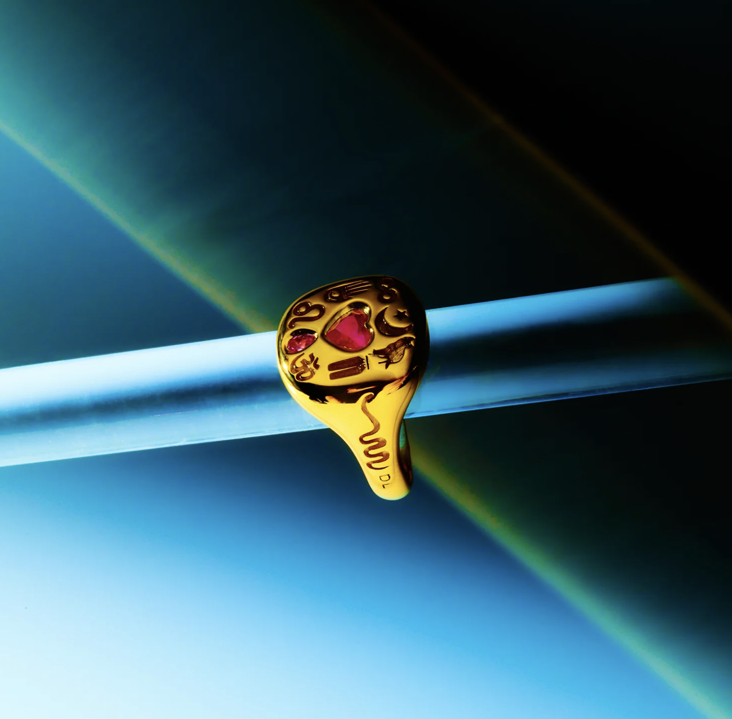A Loverglyphs signet ring by DYNE, hand-engraved in 18K gold with custom glyphs and ruby inlay — where personal symbolism becomes precious form