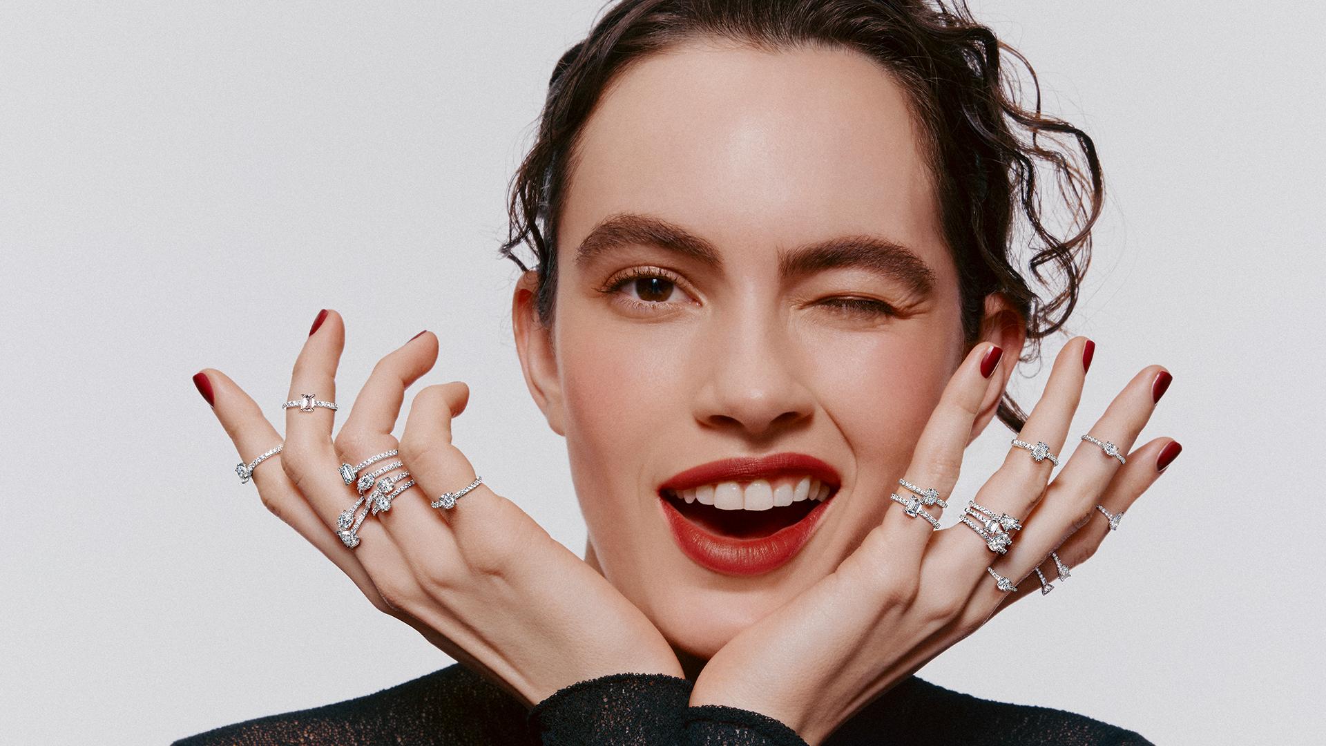 Model wearing multiple white diamond rings from Graff’s Foufou collection, featuring stacked solitaire designs in various diamond cuts set on pavé bands.