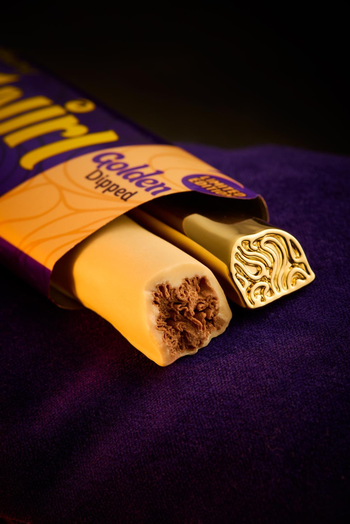 Cadbury Twirl Golden Dipped bar beside an 18-carat gold-plated Twirl replica on purple velvet