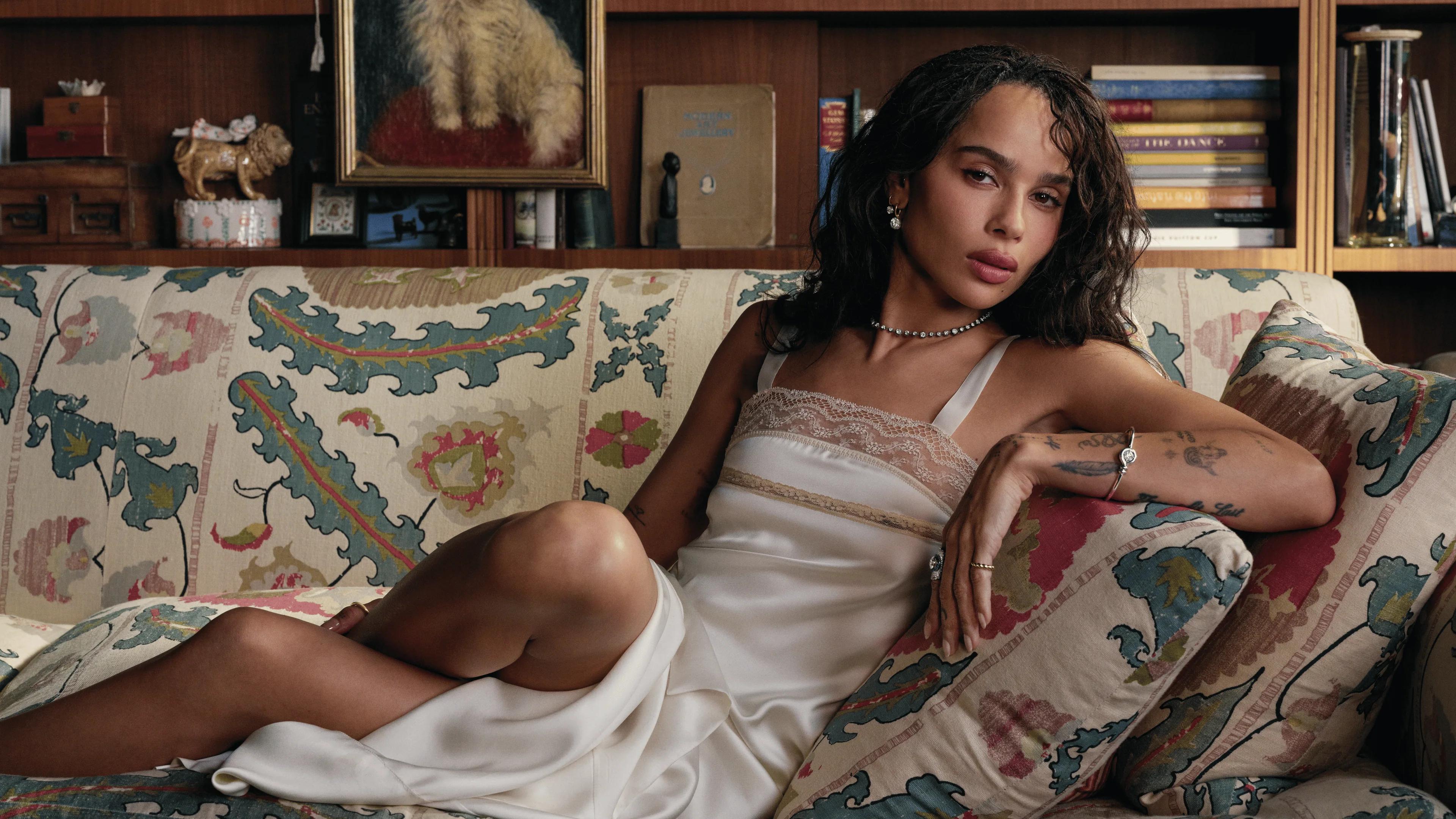 Zo&euml; Kravitz reclining on a patterned sofa wearing Jessica McCormack Day Diamonds jewellery.