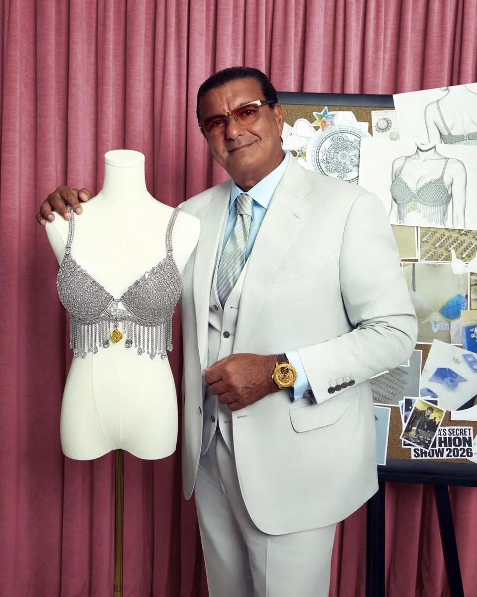 Jacob Arabo stands beside the diamond set Angel Fantasy Bra displayed on a mannequin, with sketches and development images behind him